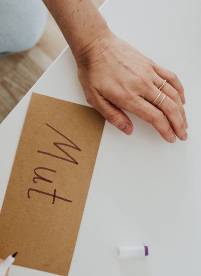 Das Bild zeigt eine Hand, die eine Moderationskarte beschriftet auf der das Wort "Mut" steht.